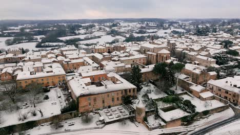 aerial view of monpazier church in the snowy morning, streets empty, market square visible, dordogne, france