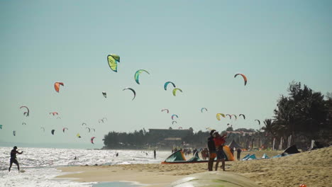 playa llena de coloridas cometas volando en un cielo azul