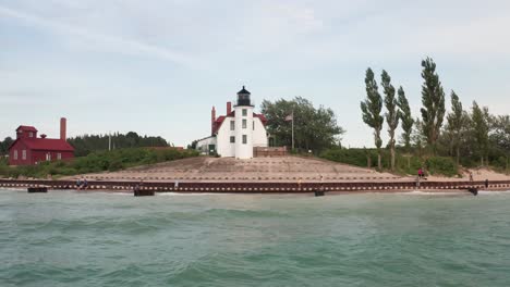historic point betsie lighthouse in frankfort, michigan located along lake michigan with drone video wide shot low moving sideways