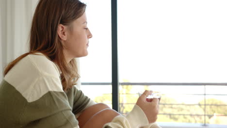 relaxing at home, young woman holding glass and enjoying peaceful moment, copy space