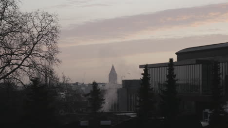 static wide shot showing skyline in background and ascending smoke,during sunrise
