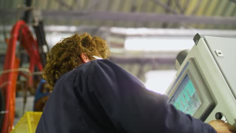 man operates a control panel at the factory low angle