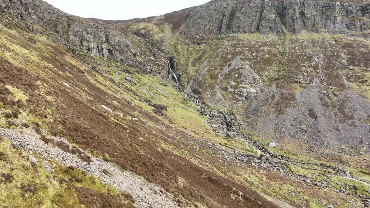 Volo sulle Cascate di Mahon nei Monti Comeragh, Waterford, sorvolando ripidi pendii coperti di erica in una mattinata di inizio primavera