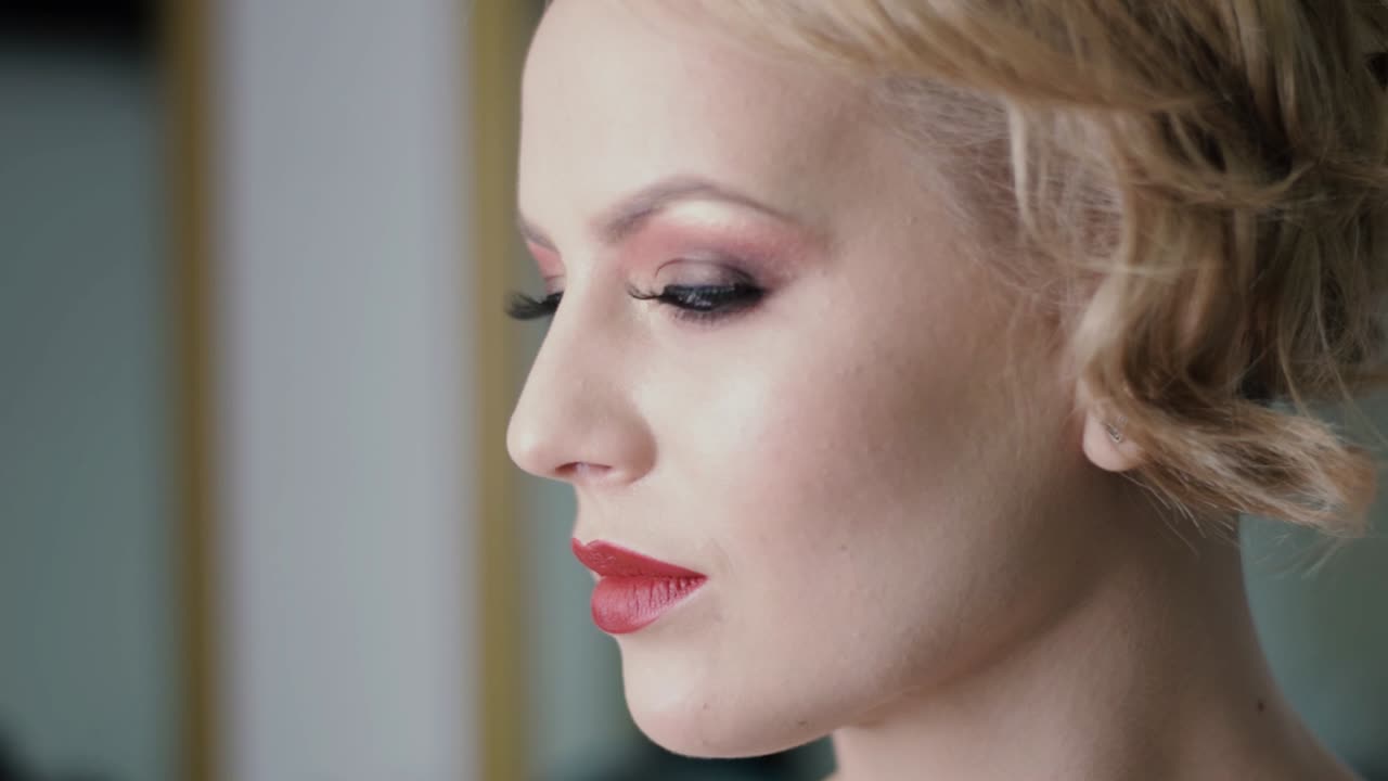 hermosa modelo rubia con ojos deslumbrantes mira hacia otro lado de la cámara y luego hacia la cámara