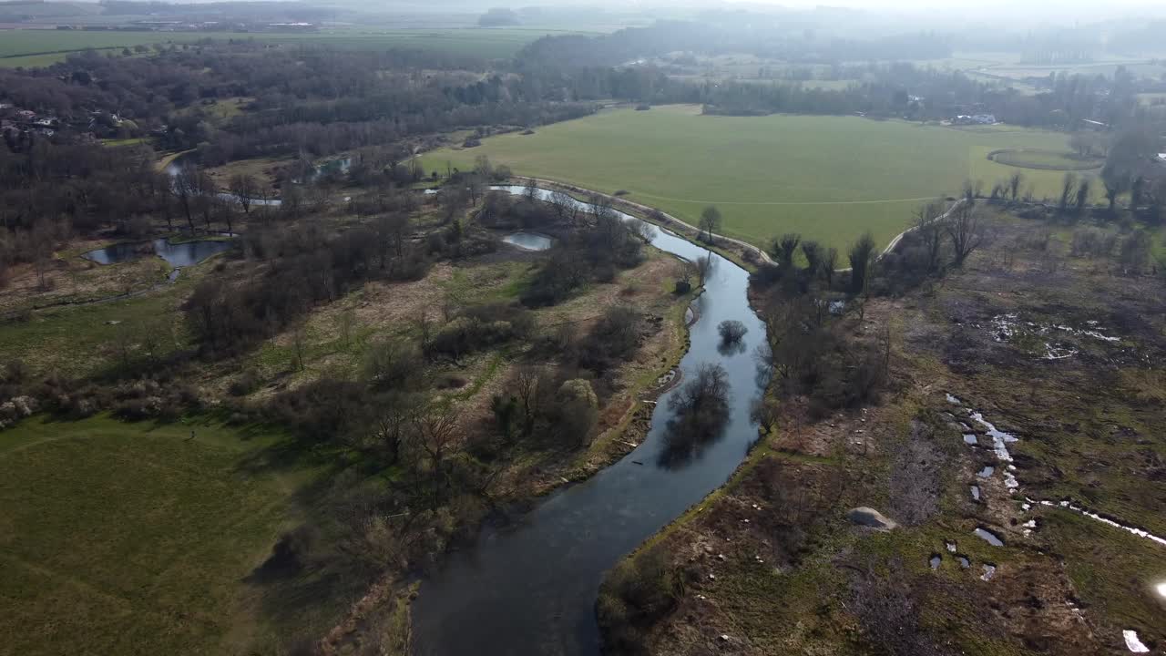 Veduta aerea zenitale di un fiume e di una zona umida nella campagna inglese.