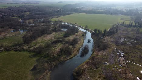 Vista-Aérea-De-Arriba-Hacia-Abajo-Del-Río-Y-El-Humedal-En-El-Campo-De-Inglaterra