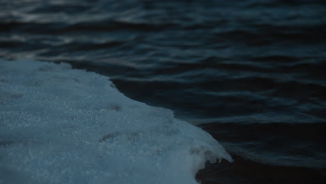 close-up of dark, rippling water on twin lake, colorado, on a cloudy day with snow-covered shores