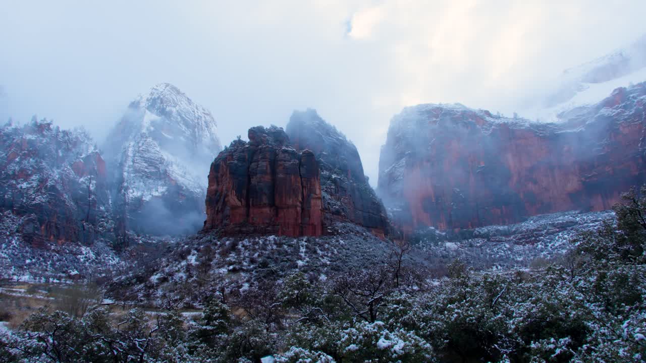 시온 국립공원 (zion national park) 의 레드 록 산맥 (red rock mountains) 의 울트라 와이드 패닝  (ultra wide panning shot) 은 산꼭대기에 눈이 내린 구름이 가득한 날입니다.