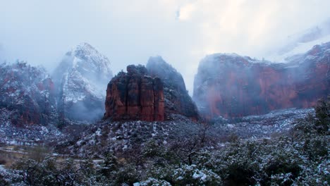 Ultra-wide-panning-shot-of-the-red-rock-mountains-in-Zion-national-park-on-an-overcast-day-with-snow-on-the-peaks