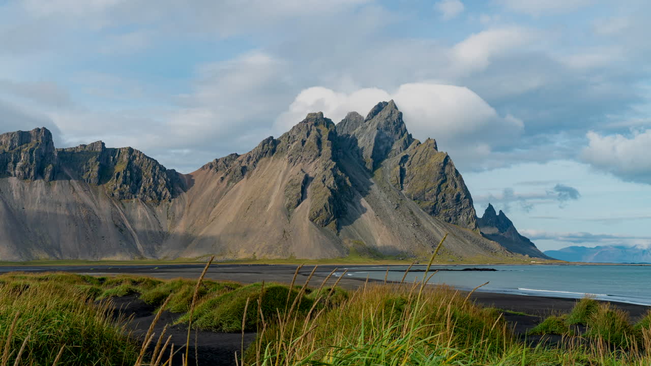 Hvide skyer der bevæger sig over Vestrahorn-bjerget i Stokksnes, Island