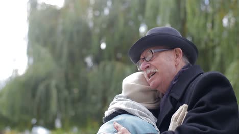elderly couple embracing outdoors