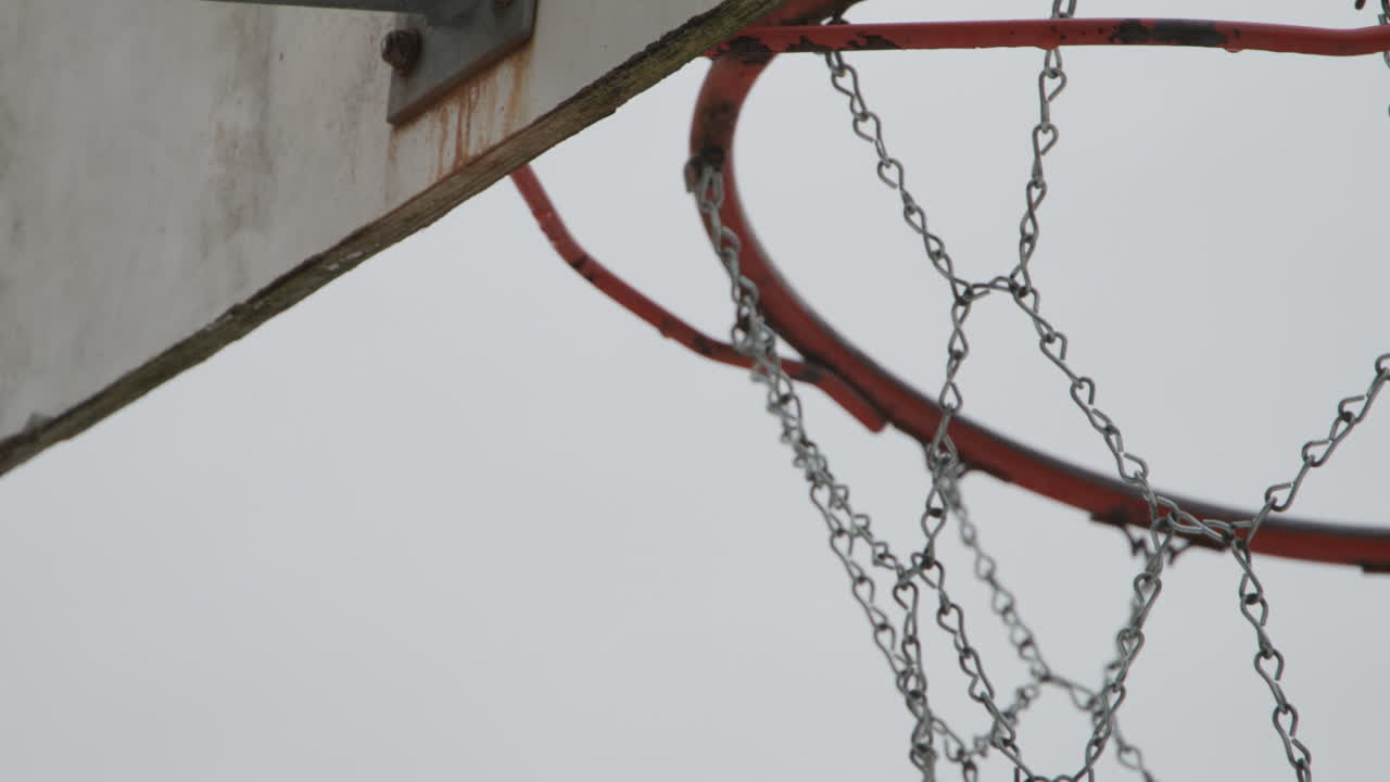primer plano de la vieja red de aro de baloncesto metálico, de mano y cámara lenta