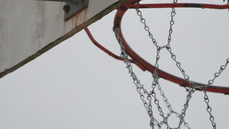 close up of old metallic basketball hoop net, handheld and slow motion