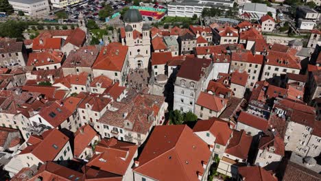 experience a stunning aerial view of the center of the historic walled city of kotor, montenegro. this shot captures the intricate layout of the old town, its terracotta rooftops.