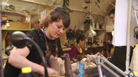 bespoke shoemaker assembling leather pieces together to make shoe