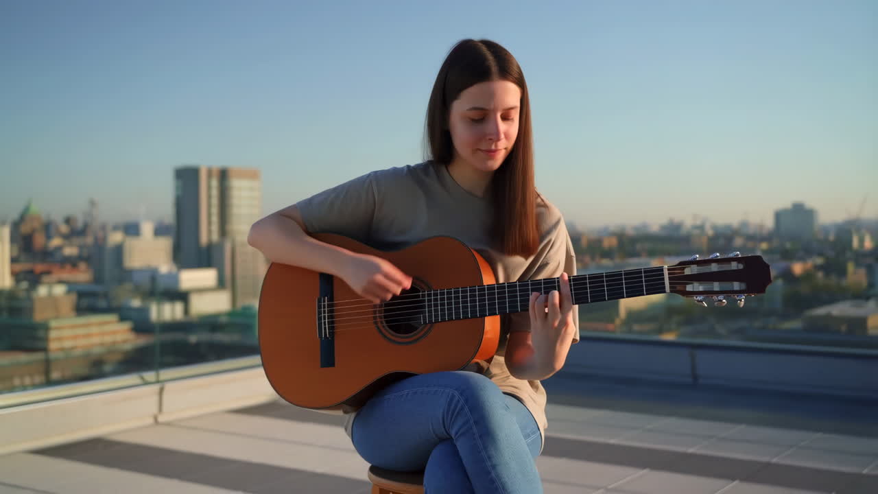 Kvinna som spelar gitarr på ett tak