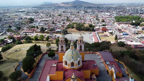 Vista-Aérea-De-La-Pirámide-Y-La-Iglesia-De-Cholula-Desde-Atrás