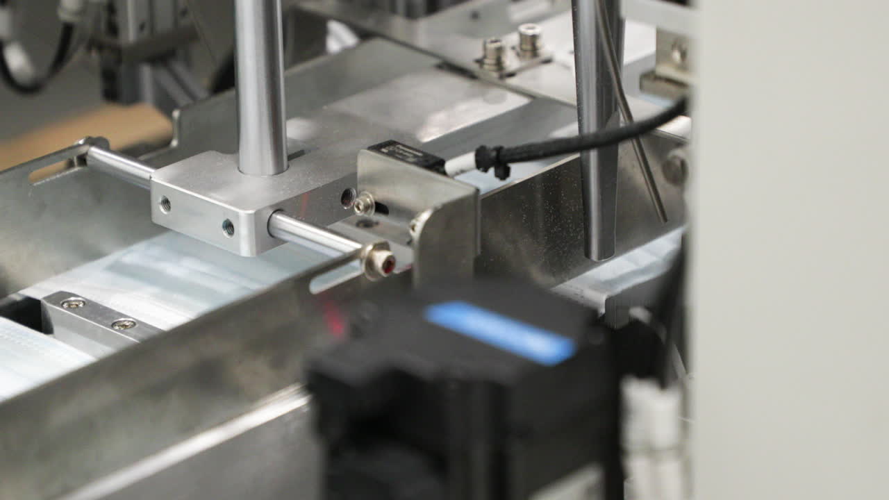 máquina que fija bucles para las orejas a telas plisadas de mascarilla quirúrgica en el transportador