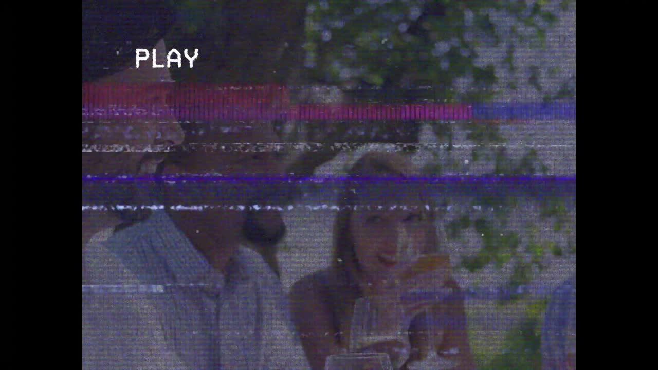 Tre amici sotto gli alberi che brindano dopo che l'uomo a sinistra alza il bicchiere, scena sociale con un overlay "VHS PLAY"
