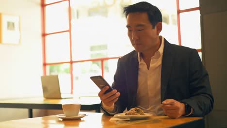 Businessman-having-food-while-using-mobile-phone-4k