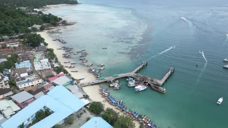 Aerial-view-of-fishing-boats-pulled-ashore-and-docked-at-coastal-town-in-Thailand