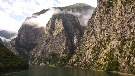 Serene-River-Flows-Calmly-Through-the-Picturesque-Valley,-Surrounded-by-Majestic-Rocky-Mountains-in-Koman-Lake,-Albania