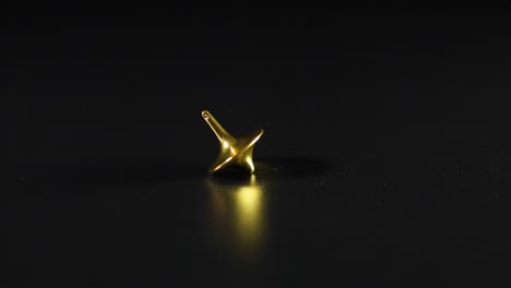 golden spinning top on black background