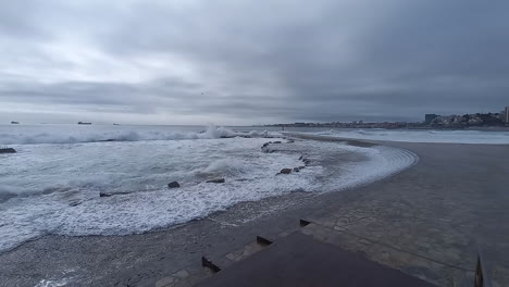 Mar-Muy-Agitado-Hace-Que-Las-Olas-Pasen-Sobre-La-Salsa-Y-Lleguen-A-La-Zona-Peatonal,-Cielo-Gris-Con-Lluvia