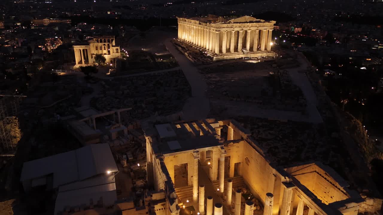 Athens, Aerial view forward towards Beautifully illuminated Acropolis at night. Close up view of Panthenon