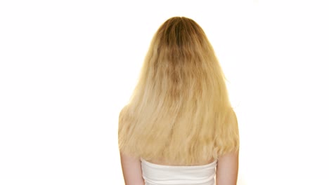 shot of the back of a slim woman with long blond hair moving her hair