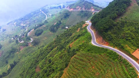 aerial dolly forward shot of vehicles traveling on a dangerous mountain road