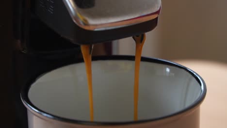 cafetera completamente automática que prepara café en una bonita taza de aspecto retro en cámara lenta