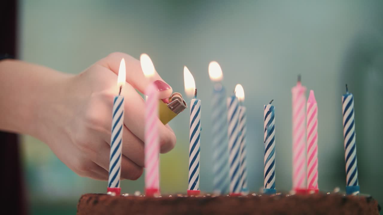 pastel de cumpleaños con velas. mano femenina luz de vela fuego con llama de encendedor