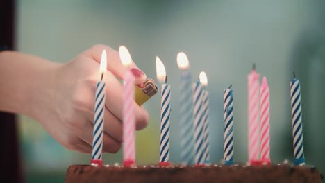 Pastel-De-Cumpleaños-Con-Velas.-Mano-Femenina-Enciende-El-Fuego-De-Las-Velas-Con-La-Llama-Del-Encendedor.