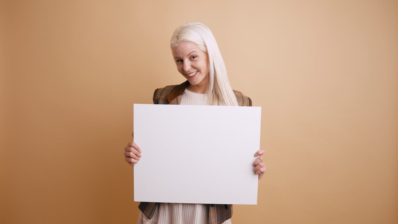 Smiling Young Woman Holding Blank White Sign in Studio
