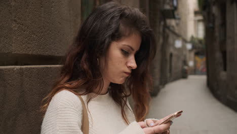 Mujer-Joven-Usando-Un-Teléfono-Inteligente-En-La-Calle