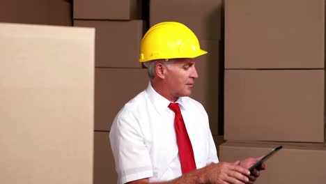 Warehouse-manager-sitting-using-his-tablet-pc