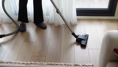 person vacuuming a wood floor
