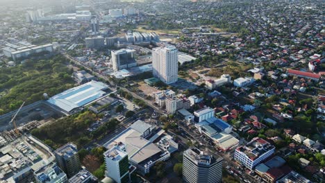 scenic aerial overview of panoramic philippine cityscape with modern buildings and rural communities during sunset