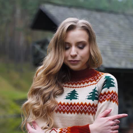 attractive girl outdoors. beautiful young woman in knitted christmas sweater standing alone in the village in cold autumn season.