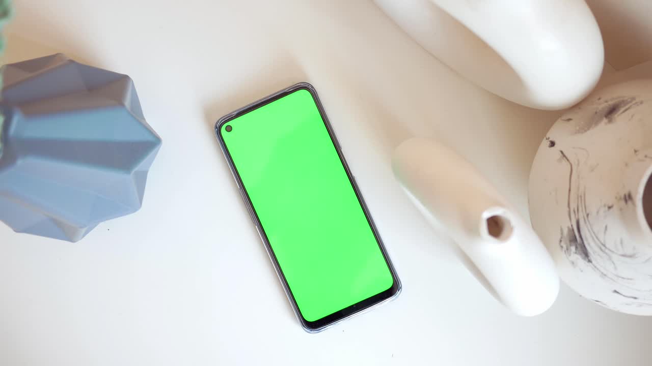 teléfono inteligente con pantalla verde y objetos decorativos