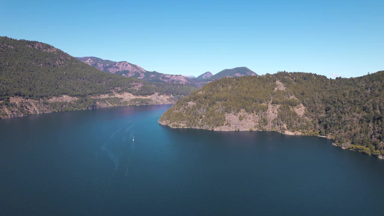 Vista aérea em 4K do Lago Lácar, perto de San Martín de los Andes, Neuquén, Argentina. Águas de azul profundo cercadas por exuberantes florestas patagônicas e verdes montanhas andinas