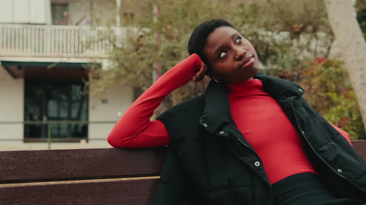 Thoughtful Young Black Woman Resting on a Bench Outdoors