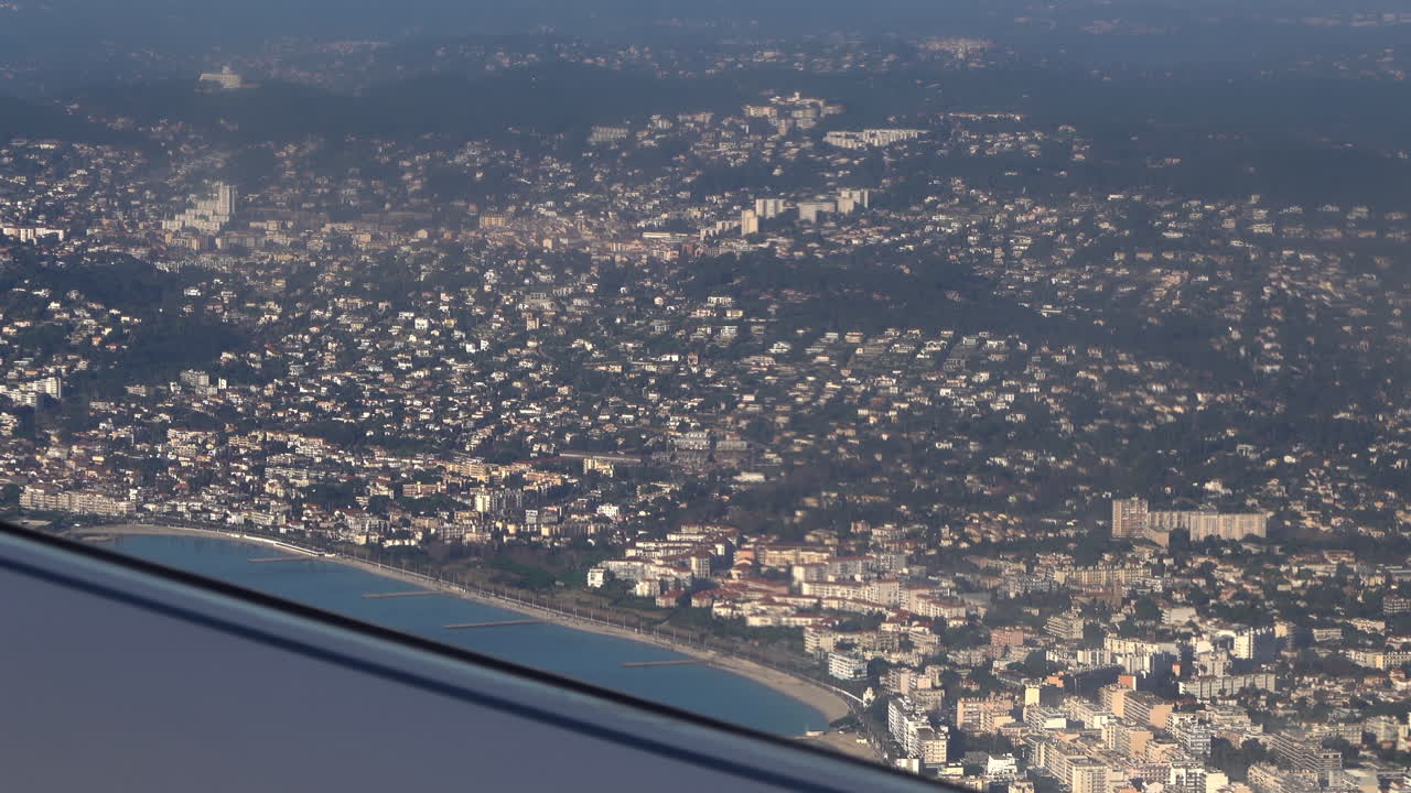 View from an airplane window of the sea and the coastal towns of the French Riviera