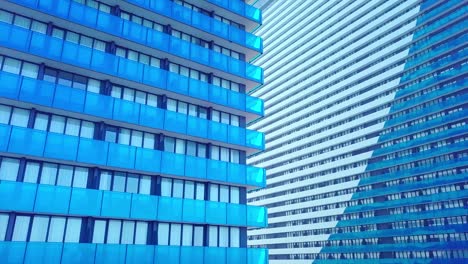 shot of reflections of sun, clouds and sky on glass windows of city skyscraper.