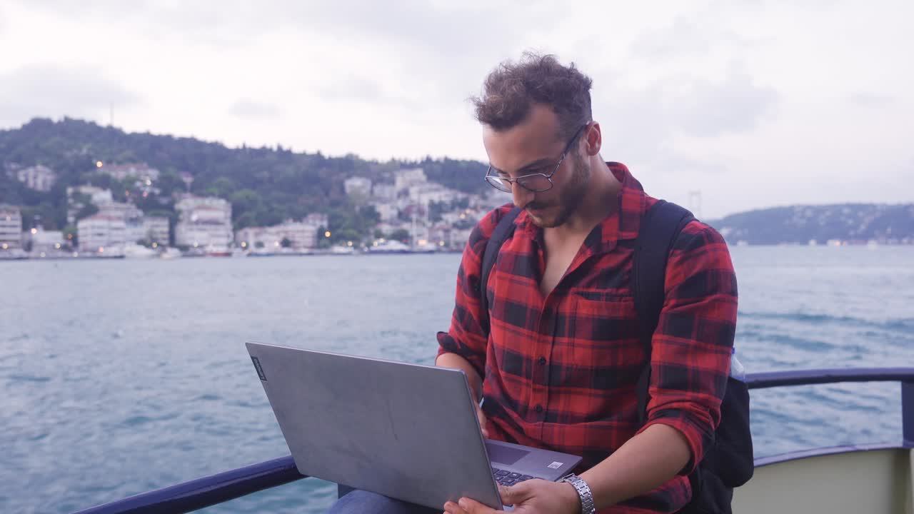 hombre trabajando en una computadora portátil en el ferry. feliz y satisfecho.