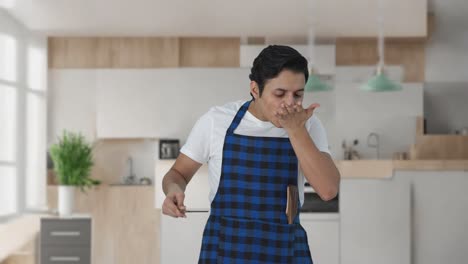 cocinero indio feliz degustando buena comida y dándole un beso al chef