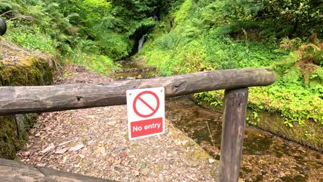 sign blocking path in lush green area