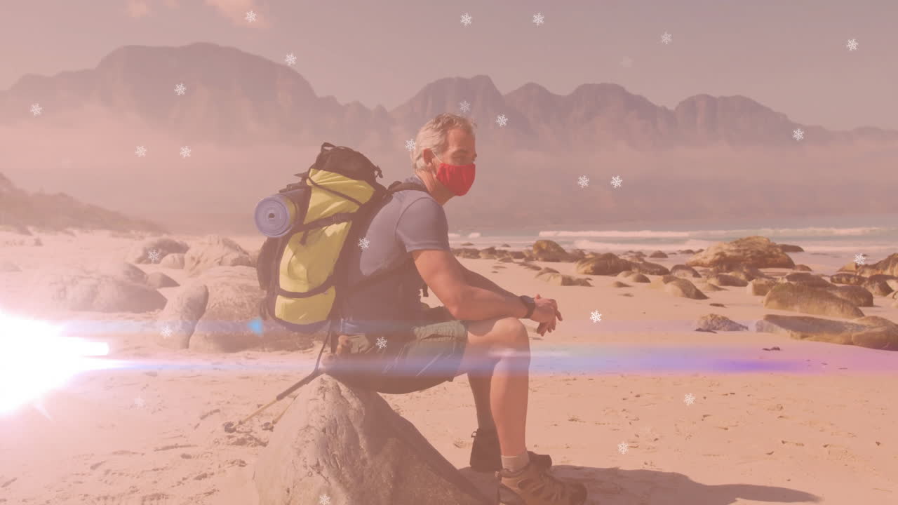 male hiker resting on rock at beach, showcasing health technology with digital snowflake overlays