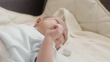 close up of a cute newborn baby lying on bed and crying 1